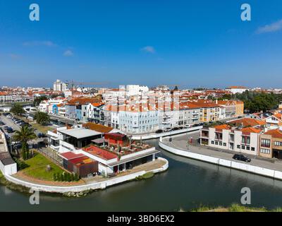 Drohnenblick auf die pulsierende Stadtlandschaft mit roten Dächern, Kanal und Palmen Stockfoto