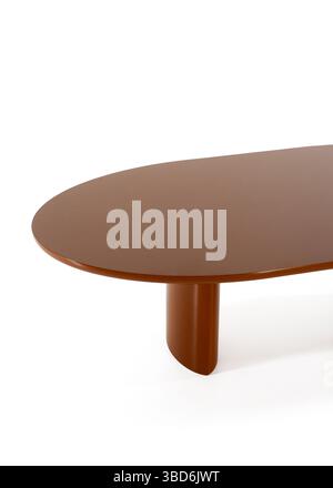 Ein Studio-Shot zeigt einen modernen ovalen Esstisch in Braun mit minimalistischem Design und einem einzigen zylindrischen Bein. Der Tisch ist isoliert Stockfoto