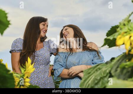 Zwei glückliche Frauen, die auf dem Maisfeld lachen Stockfoto