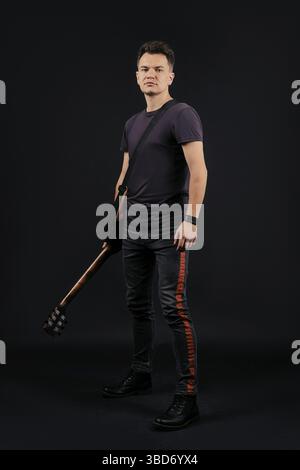 In voller Länge Porträt in Low Key von Musiker mit Gitarre Stockfoto
