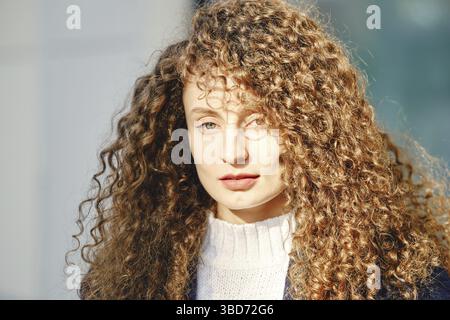 Sonnenbild einer Frau mit braunem lockigem Haar Stockfoto