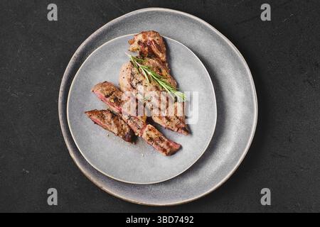 Blick von oben auf ein saftiges Ribeye-Steak auf einem Teller Stockfoto