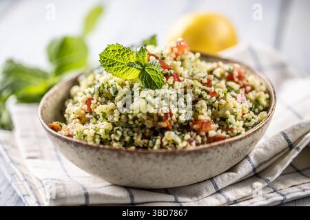 Traditioneller Tabouleh-Salat mit Bulgur, Petersilie, Gurke, Tomate, Koriander, Knoblauch, Minze und andere Zutaten. Stockfoto