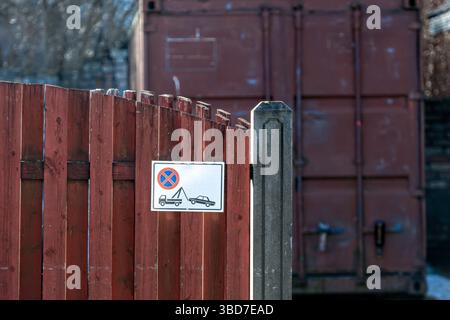 Auf einem Holzzaun neben den Lagerbehältern ist ein Schild mit den Parkvorschriften zu sehen. Stockfoto