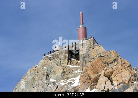 Ein Blick auf die Menschen auf einer Aussichtsplattform auf der Spitze der Seilbahnstation Aiguille du Midi über der französischen Bergstadt Chamonix an einem sonnigen Tag. Stockfoto