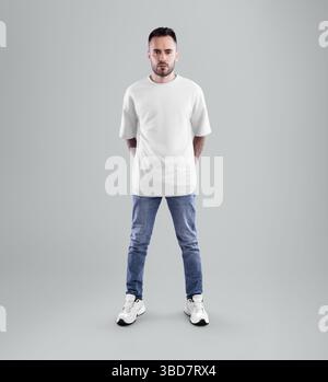 Modell eines weißen Oversize-T-Shirts auf bärtigen Mann in blauer Jeans, Hände hinter dem Rücken, in voller Länge, Vorderansicht, isoliert auf dem Hintergrund. Freizeit Hemd T Stockfoto