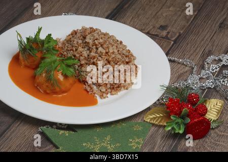 Buchweizenbrei und Fleischbällchen auf Holztisch in der Nähe von Cristmas-Baumspielzeug Stockfoto