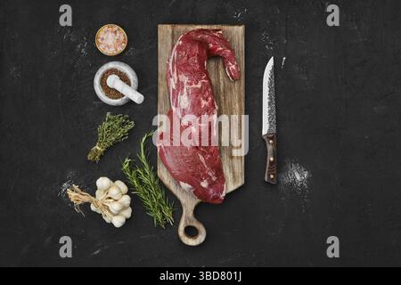 Blick von oben auf das dreispitzige Roh-Rind-Lendenstück auf Holzschnitt Platine Stockfoto
