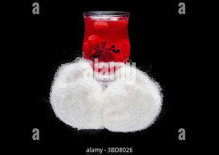 Hände in warme Handschuhe, die heiße Tasse mit Kräutertee halten Stockfoto