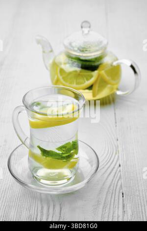Antioxidative Heißgetränk mit Zitrone und Minze in transparentem Tee Topf und Glas Stockfoto