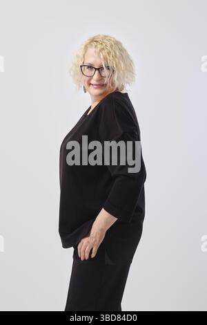 Porträt einer lächelnden Frau mittleren Alters mit kurzen blonden Locken im Profil Stockfoto