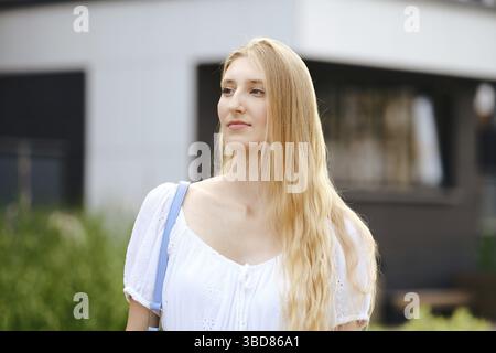 Außenporträt einer jungen Frau mit langen blonden Haaren Stockfoto