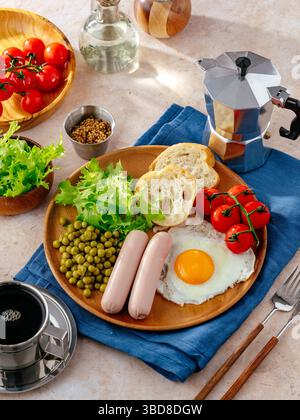 Englisches Frühstück mit Eiern, Würstchen und grünen Erbsen Stockfoto