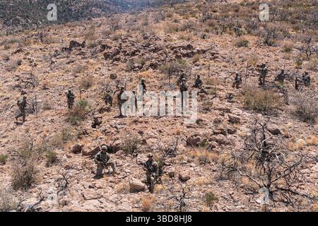US Army Soldiers, 76th Engineer Company, die der Joint Task Force–Southern Border zugeordnet ist, erwerben am 20. Mai 2025 Streikposten für die New Mexico National Defense Area (NMNDA)-Unterschriftenmission in der Nähe von Antelope Wells, New Mexico. Die Materialien wurden durch die Luftzufuhr bereitgestellt, da das strenge Gelände das Manöver am Boden einschränkte. Unter der Leitung des U.S. Northern Command bündelt die Joint Task Force–Southern Border die Bemühungen, die südliche Grenze zu besiegeln und illegale Aktivitäten abzuwehren, und ist für umfassende, agile und domänenübergreifende Operationen verantwortlich, die effektivere und effizientere Operationen des Verteidigungsministeriums ermöglichen Stockfoto