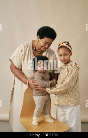 Porträt einer afroamerikanischen Familie der drei Generationen, die zusammen einen liebevollen Moment festgehalten hat. Großmutter, Tochter und Baby teilen eine warme, herzwärmende Stockfoto