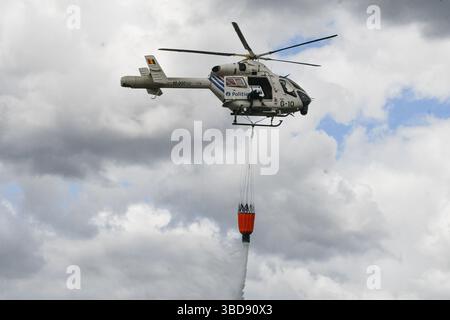 Maasmechelen, Belgien. Mai 2025. Die Abbildung zeigt einen Polizeihubschrauber, der am Freitag, den 23. Mai 2025, einen bambi-Eimer benutzt, um Wasser auf ein Feuer im Nationaal Park Hoge Kempen in AS zu kippen. Feuerwehren aus der Ost-Limburger Rettungszone wurden am Donnerstag, den 22. Mai 2025 Abend gegen 21.00 Uhr zu einem Waldbrand in der Mechelse Heide auf dem Gebiet von Maasmechelen und AS massenhaft ausgerufen. BELGA FOTO PINO MISURACA Credit: Belga Nachrichtenagentur/Alamy Live News Stockfoto