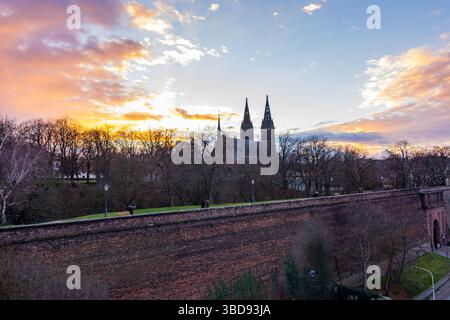 Prag, Tschechische republik: Panorama der Vysehrader Basilika während des Sonnenuntergangs. Orangefarbene Wolken über der alten Kirche in der tschechischen Hauptstadt. Stockfoto