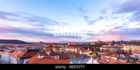Prager Panoramablick vom Schloss Vysehrad. Stadtbild während des Sonnenuntergangs, magische und wunderschöne Farben. Bunte Wolken über der tschechischen Hauptstadt. Stockfoto
