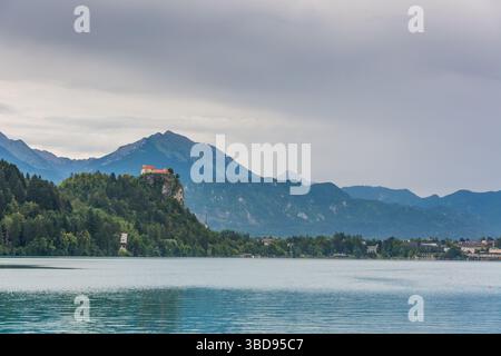 Verblutete Burg nach dem Sturm. Dunkelgrauer Himmel mit Wolken über dem Bleder See Stockfoto