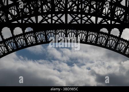 Silhouette von eisernen Teilen auf dem Eiffelturm und Blick auf den bewölkten Himmel. Stockfoto