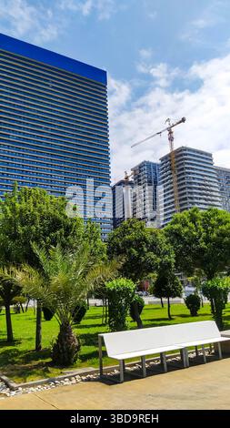 Moderne Hochhäuser im Bau stehen im Kontrast zu alten Wohnwohnungen in einem Stadtpark. Städtische Transformation und der Zusammenprall des Architekten Stockfoto