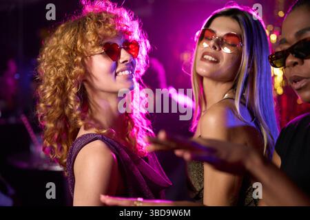 Fröhliche Frauen tanzen zusammen auf der Nachtclub-Party Stockfoto