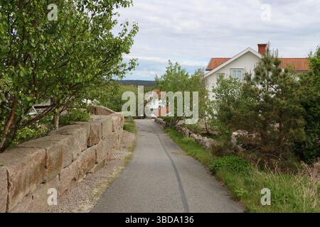 Eine kleine Straße und Häuser auf dem Berg Vetteberget über Fjällbacka Dorf und Hafen an der Westküste Schwedens, Mai 2025 Stockfoto