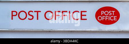 Ein einfaches Postzeichen mit roter Schrift auf weißem Hintergrund und rundem Logo. Stockfoto