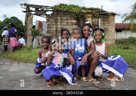 PARAMARIBO - Kinder auf der Straße im Stadtteil Tammenga mit NDP-Fahnen um ihre Körper vor den Wahlen. Diese Gemeinde floh Ende der 1980er Jahre aus dem Inlandskrieg und ließ sich hier nieder. Suriname nimmt am 25. Mai an den Wahlen Teil, an denen insgesamt 14 politische Parteien und Parteienkombinationen teilnehmen. ANP RAMON VAN FLYMEN niederlande aus - belgien aus Stockfoto