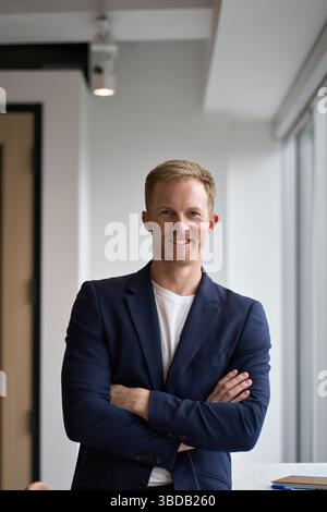 Glücklicher junger Geschäftsmann im Büro, Porträt. Stockfoto