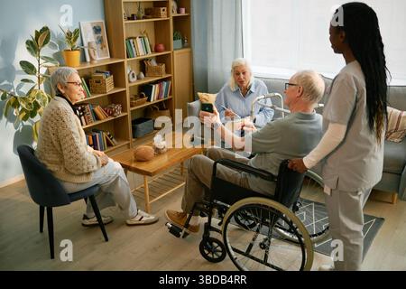 Gruppe von Senioren, die im Zimmer soziale Aktivitäten ausüben Stockfoto