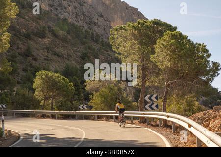 Eine Radfahrerin fährt auf einer Bergstraße bei A Stockfoto
