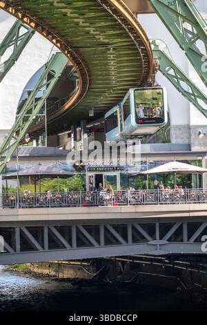Wuppertaler Schwebebahn entlang der Wupper, an der Haltestelle Hauptbahnhof, Terrasse eines Restaurants auf einer Brücke über den Fluss, Nein Stockfoto