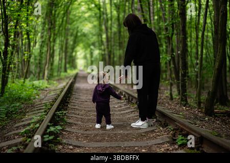 Ein ruhiger Moment, in dem Mutter und Kind in der Umarmung der Natur zusammenhängen. Stockfoto