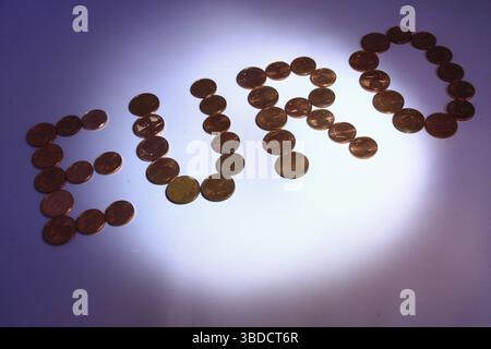 Euro-Cent-Münzen, die den Buchstaben EURO in dramatischer Beleuchtung bilden Stockfoto