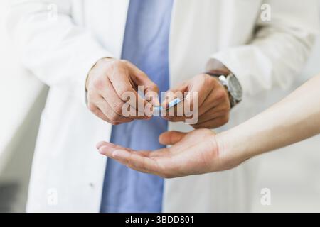 Arzt gibt Pillen Stockfoto