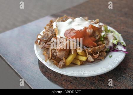 Döner-Dönerteller mit Fleisch, Pommes frites, Salat und zwei Saucen in einem türkischen Fast-Food-Restaurant in Deutschland, Kopierraum, ausgewählter Fokus, sehr Stockfoto