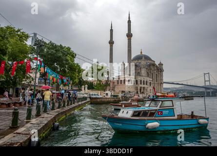 Fischerboote legten im Bosporus neben der Ortakoy Camii (Moschee) in Ortakoy in Istanbul an. Stockfoto