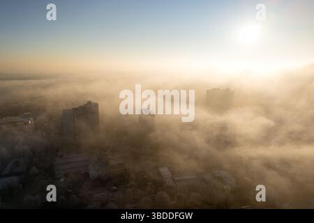 Luftbild der Hochhäuser im Morgennebel während des dramatischen Sonnenaufgangs Stockfoto