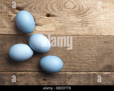 Natürlich gefärbte Bio-Eier auf einem rustikalen Tisch mit Platz für Text, Osterhintergrund Stockfoto