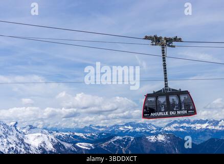 Eine Seilbahn mit der Aufschrift „Aiguille du Midi“ über der berühmten französischen Bergstadt Chamonix, mit einer wunderschönen Bergkulisse im Hintergrund. Stockfoto