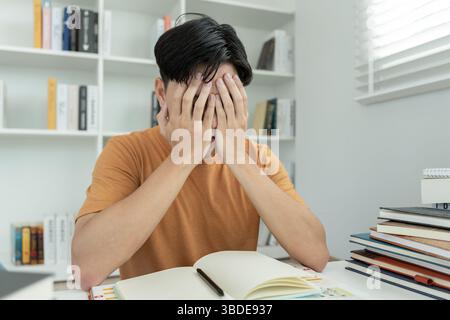 Asiatische Studentinnen haben Angst wegen Prüfungen, männliche bereiten sich auf Test und Lernstunden in der Bibliothek vor. Stress, Verzweiflung, Eile, Missverständnis r Stockfoto