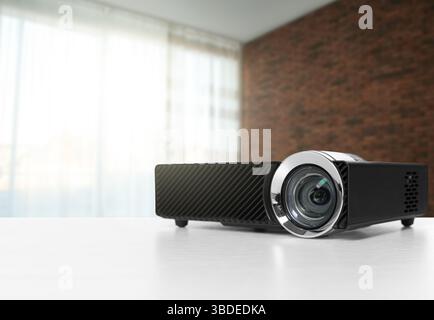 Moderner Videoprojektor auf weißem Tisch im Zimmer Stockfoto