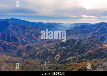 Atemberaubender Weitwinkelblick auf das weitläufige Bergtal im Sequoia-Nationalpark mit mehrschichtigen Graten und einer trüben Atmosphäre unter bewölktem Himmel Stockfoto