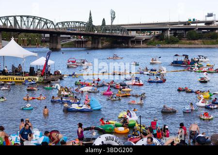 The Big Float, Portland, Oregon – 14. Juli 2018: Die Menschen schweben auf dem Willamette River in Schlauchbooten und Röhren und genießen die Musik von einem Lastkahn. Stockfoto