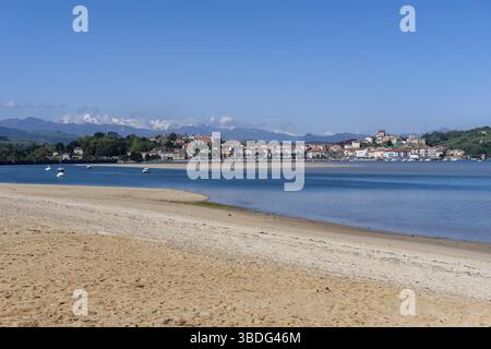 San Vicente de la Barquera, Spanien - 25. April 2022: Panoramablick auf den Maza-Strand und San Vicente de la Barquera mit den Picos de Europa-Bergen im b Stockfoto