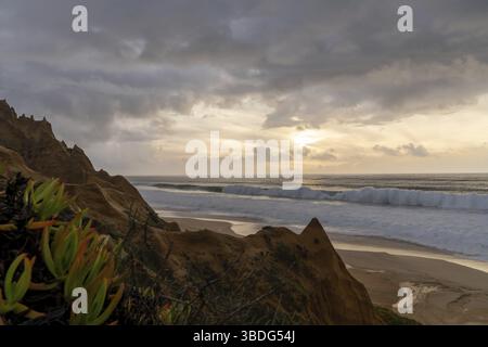 Viele bizarre erodierte Sanddünen am Atlantischen Ozean mit Wellen Rollen bei Sonnenuntergang ein Stockfoto