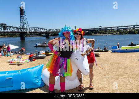 The Big Float, Portland, Oregon – 14. Juli 2018: Zwei Frauen posieren mit einem aufblasbaren Einhorn beim jährlichen Big Float Event am Willamette River. Stockfoto