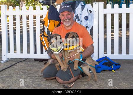 The Big Float, Portland, Oregon – 14. Juli 2018: Ein Mann mit einem „Dog Dad“-Hut posiert mit zwei Hunden, die Schwimmwesten tragen, und bereitet sich auf einen Fluss vor. Stockfoto