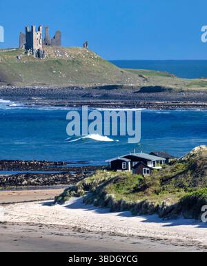 Blick im Frühling an einem sonnigen Tag mit Blick auf Dunstanburgh Castle an der Northumberland Coast von Low Newton-by-the-Sea bei Ebbe Stockfoto
